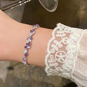 Vue détaillée d'un élégant bracelet en zircone violet et blanc porté à un poignet