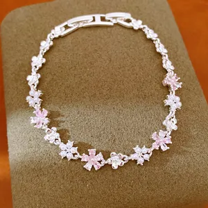 Gros plan d'un bracelet en argent avec des fleurs en zircon rose et des perles