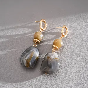 Close-up detail view of vintage irregular geometric resin earrings with gold accents