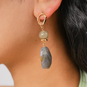 Detail shot of vintage geometric resin drop earrings in gold and gray marble textures.