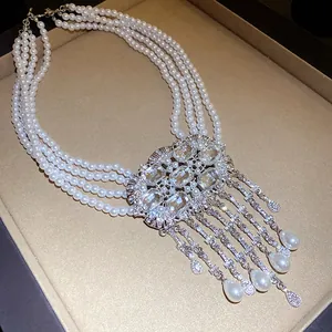 Detail view of a multi-layer pearl necklace featuring crystal accents and teardrop tassels