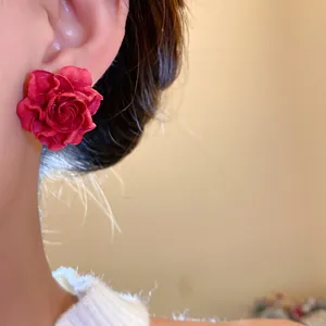 Close-up of elegant red rose flower stud earring showing delicate and realistic petal texture