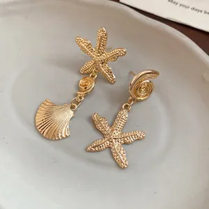 Detailed texture of gold starfish and seashell asymmetrical drop earrings set