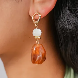 Detailed close-up view of vintage irregular geometric resin earrings with amber beads