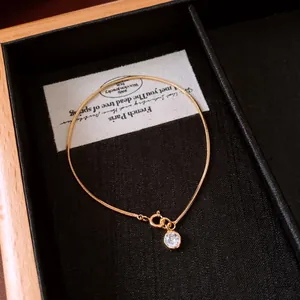 Detail shot of 18k gold plated bracelet with sparkling round zircon pendant