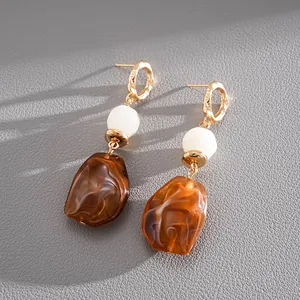 Close-up of vintage resin geometric drop earrings with brown marbled texture