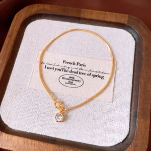 Close-up of 18k gold plated bracelet featuring a sparkling round zircon pendant.
