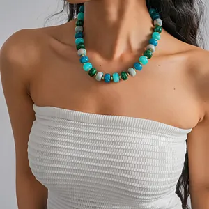 Detailed macro view of colorful acrylic swirl patterned beaded necklace worn on model neck