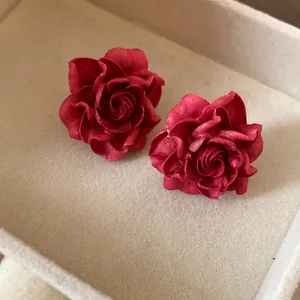 Close-up macro view of vintage elegant matte red rose flower stud earrings in box