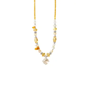 Elegant yellow beaded necklace with a clear zircon flower pendant on white backdrop