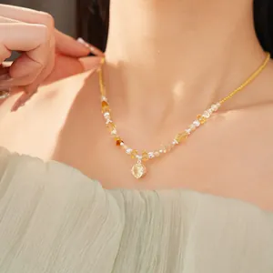 Close-up shot of a yellow beaded necklace with a round stone pendant on a model