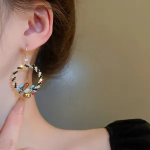 Nahaufnahme eleganter Strass Kristallkreis Ohrringe mit bunten Edelsteinen am Ohr