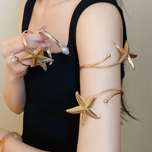 Close-up of elegant gold and silver starfish arm cuffs and pearl bangles on female model