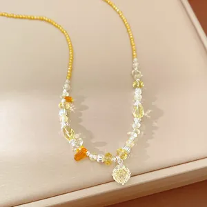 Detailed view of a yellow beaded necklace featuring a sparkling zircon flower pendant.
