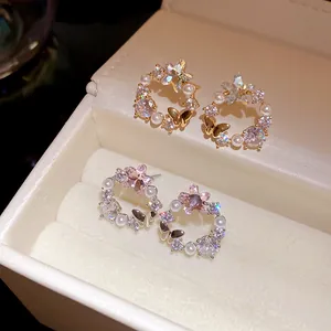 Detailed view of exquisite 18k gold plated butterfly stud earrings with pearls and zircon stones