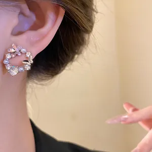 Detailed view of elegant 18k gold plated butterfly earrings with pearls and zirconia