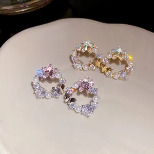 Detail of 18k gold plated butterfly stud earrings with pearls and pink star zircons