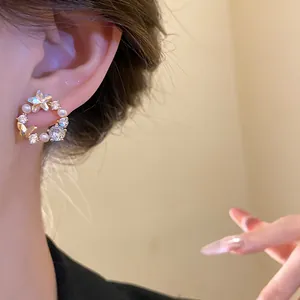 Close-up of elegant 18k gold plated butterfly and pearl earring on ear