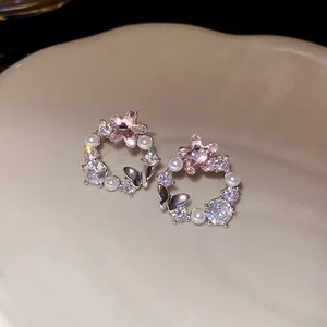 Macro view of elegant 18k gold plated stud earrings with stars, pearls, and zircons.
