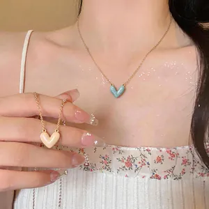 Close-up view of 14k gold plated drip oil heart pendant necklace worn on a model's neck