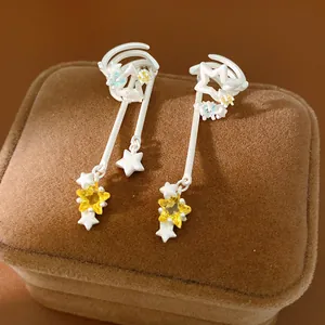 Macro detail of silver-tone star tassel ear clips with sparkling yellow cubic zirconia