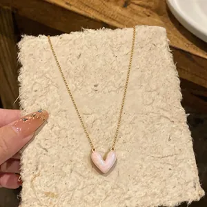 Close-up of elegant 14k gold plated necklace with a pink marble heart pendant