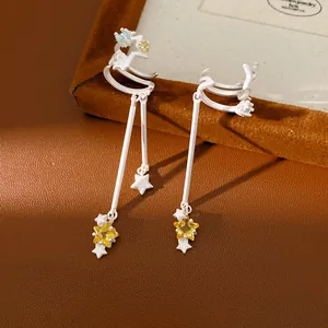 Detailed view of elegant silver star tassel ear clips with sparkling yellow zircon accents