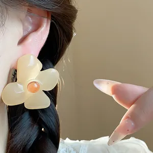 Close-up of vintage resin flower stud earrings with elegant cream petals