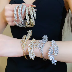 Detailed shot of elegant zircon leaf crossover open bracelets in silver and gold finishes.