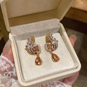 Vintage gold finish drop earrings with champagne zircons in a cream jewelry box