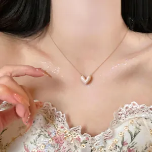 Close-up of elegant 14k gold plated necklace with cream enamel heart pendant