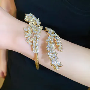 Detailed view of an elegant gold zircon leaf wrap bracelet worn on a woman's wrist