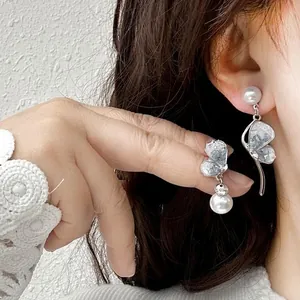 Detailed view showing the intricate crystal butterfly and pearl elements of the earring.