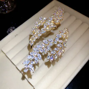 Macro detail of a triple-layer cubic zirconia leaf open bangle bracelet with gold finish