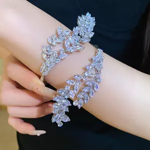 Detailed view of a sparkling zircon three-layer leaf open bangle on a model's wrist