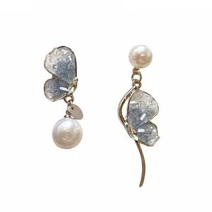 Elegant asymmetrical light blue crystal butterfly earrings with delicate white pearls