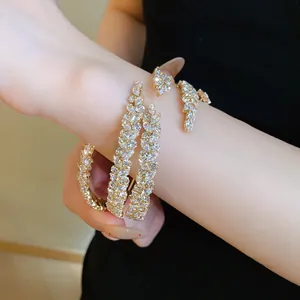 Detail view of a sparkly gold-tone zircon three-layer leaf wrap bracelet on a wrist