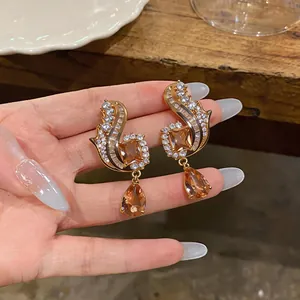 Elegant vintage-style golden earrings featuring champagne zircon and teardrop pendants.