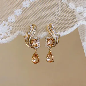Close-up detail of luxury champagne teardrop pendant earrings with sparkling zircon.