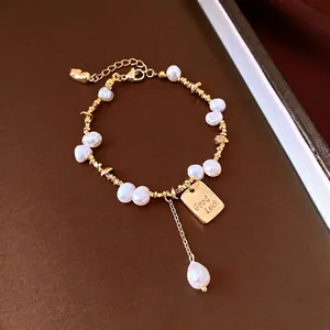 Elegant 18K gold plated pearl bracelet featuring a Good Luck charm and dainty gold beads