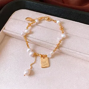 Elegant 18K gold plated pearl charm bracelet with Good Luck tag displayed in jewelry box