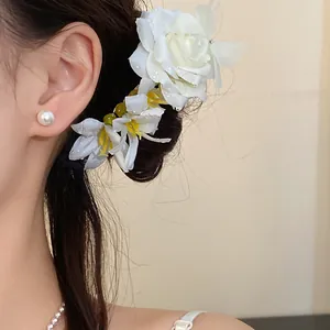 Close-up detail of an elegant white rose flower hairpin worn by a model in a sweet style