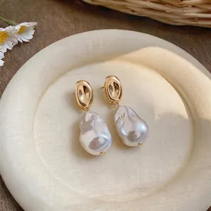 Exquisite French retro style earrings with irregular baroque pearls on a cream tray