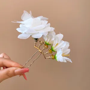 Elegant white fabric flower hairpin with butterfly detail in gold finish for weddings