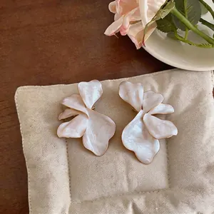 Elegant oversized white flower stud earrings featuring a unique pearlescent oil finish