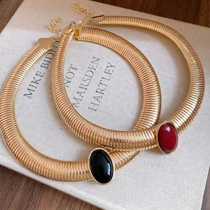 Elegant vintage gold-toned metal torque choker necklace with an oval resin stone detail.