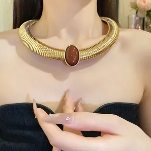Vintage palace style gold metallic choker with oval brown resin stone worn by model