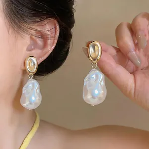Detailed close-up view of French vintage irregular baroque pearl drop earrings in gold finish