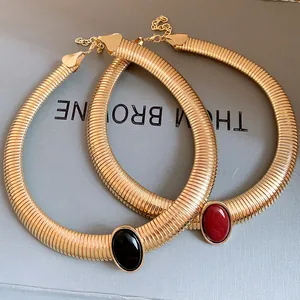 Detail shot of vintage gold metal chokers with black and red oval resin stones