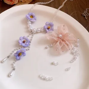 Macro view of chiffon flower and pearl beaded details on a fashionable sweet necklace